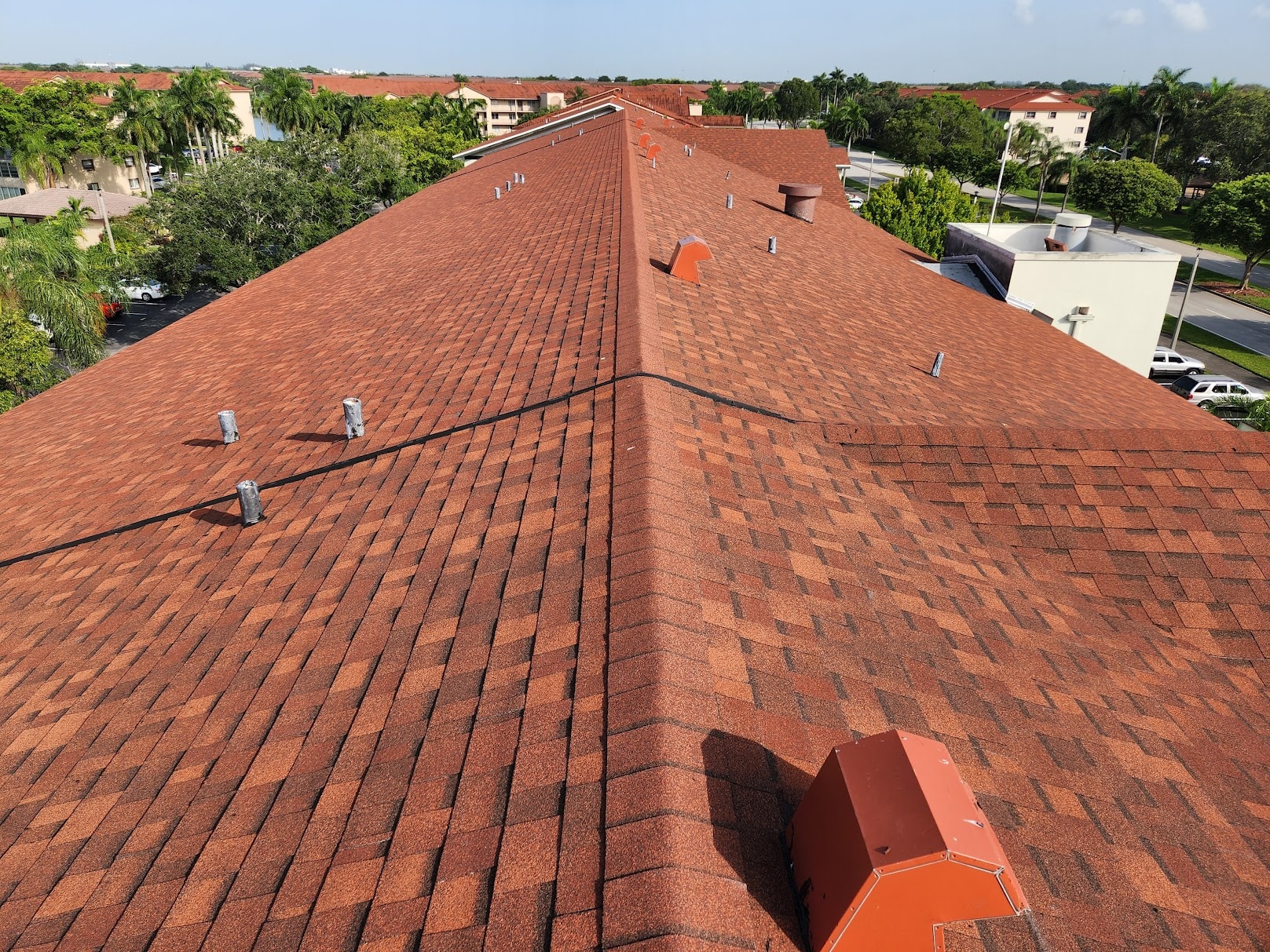 Completed red shingle condo roof full aerial view with parking lot – Job 22-072-G