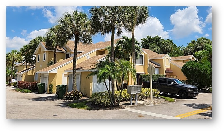 Yellow condo townhome complex exterior after roof replacement – Job 23-009