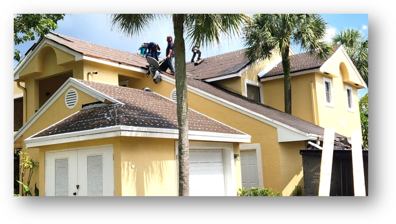 Crew installing shingles on yellow condo townhome complex – Job 23-010