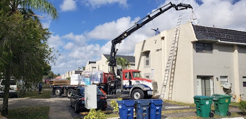 Crane truck delivering roofing materials to Century Gardens condo complex – Lauderhill, FL