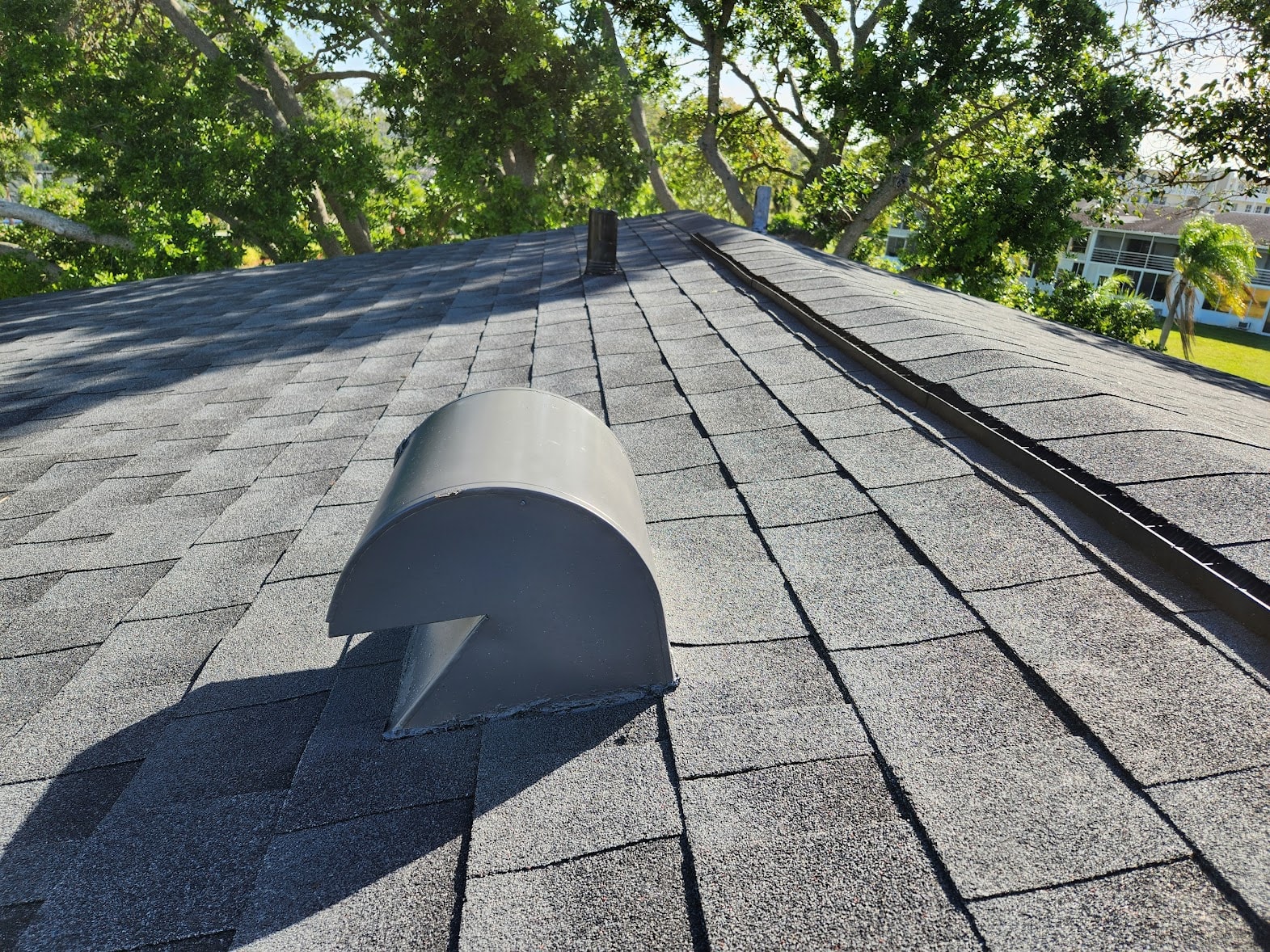 Completed gray shingle condo roof with vent detail – Lyndhurst