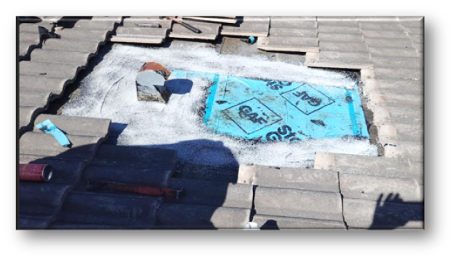 Concrete tile repair area with bright blue GAF SBS membrane installed, tiles staged around perimeter – Job 26-098