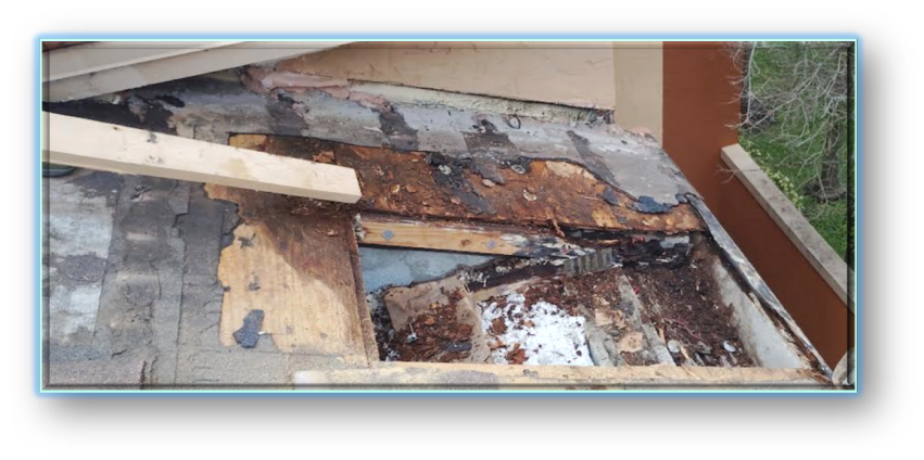 Wide view of severely deteriorated roof deck with rotted wood, old underlayment, and debris – Job 26-132