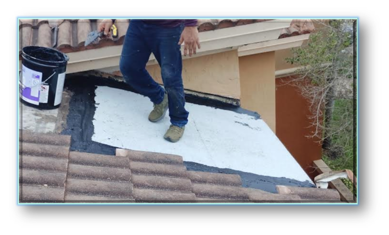 Roofer applying white waterproofing membrane coating on flat roof section adjacent to clay barrel tiles – Job 26-132
