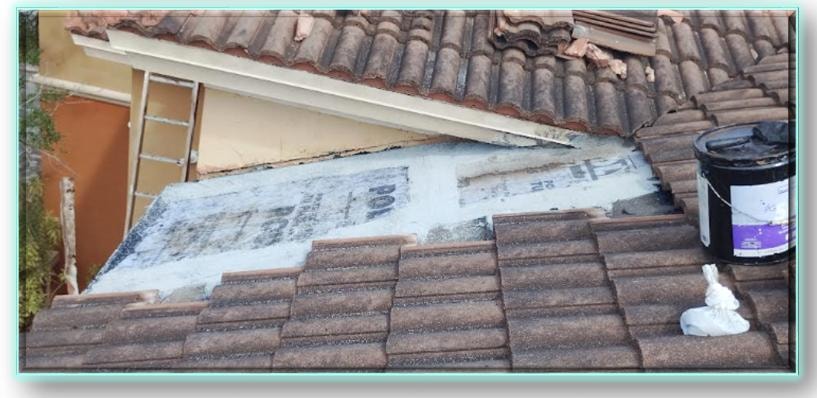 Concrete barrel tile roof repair in progress – new underlayment membrane installed with roofing adhesive bucket staged and tiles partially reinstalled