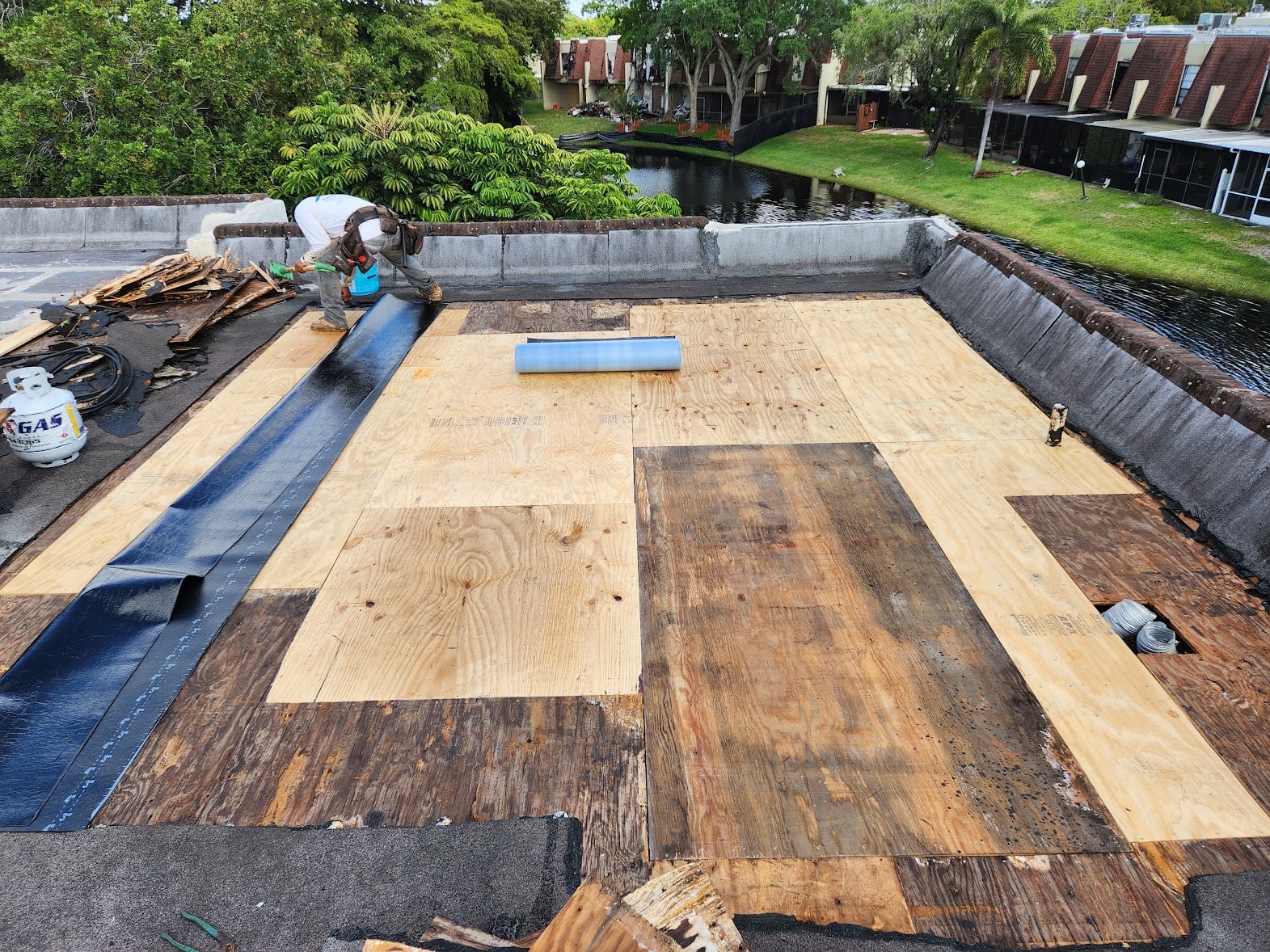New plywood decking installed over flat roof during repair