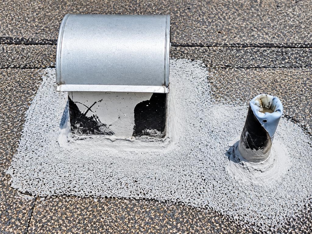 Rooftop vent and plumbing stack sealed with fibered coating — rooftop hardware maintenance by Artisan Roof Specialists