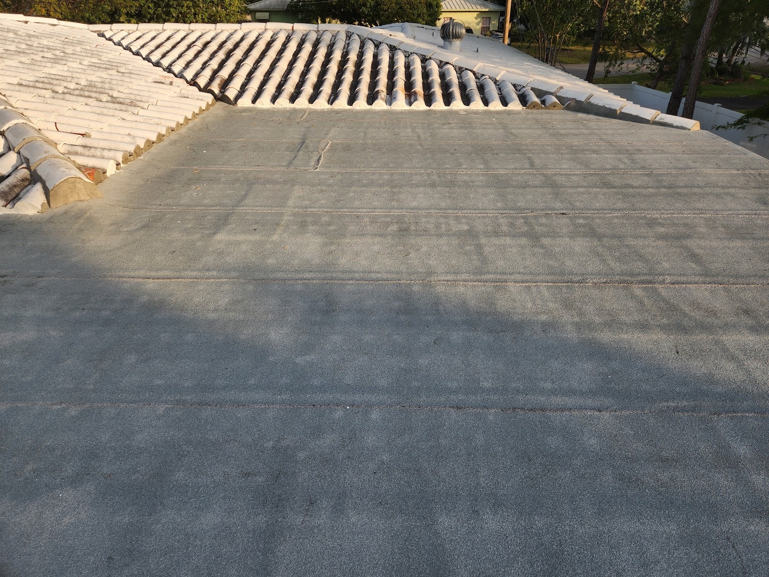 Completed flat roof membrane adjacent to barrel tile roof – March 2025