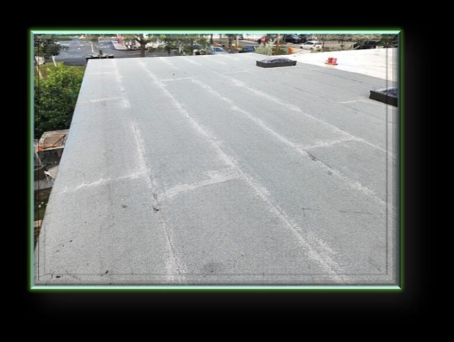 Completed commercial flat roof installation with smooth modified bitumen surface and skylight – Artisan Roof Specialists
