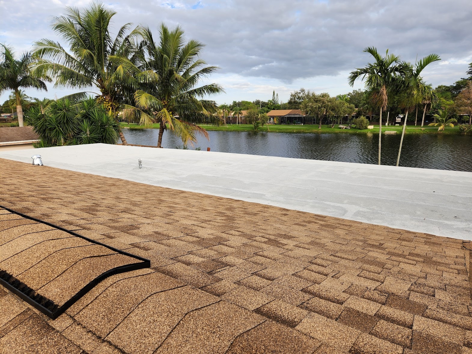 Completed flat and shingle combination roof with waterfront lake view – Pines